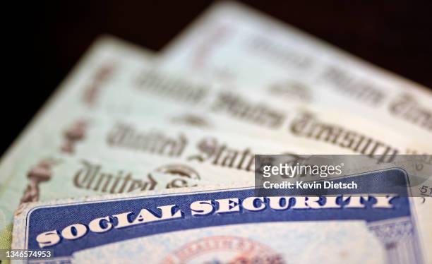 In this photo illustration, a Social Security card sits alongside checks from the U.S. Treasury on October 14, 2021 in Washington, DC. The Social...