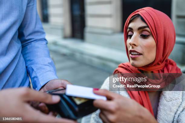 muslim mature woman paying for cafe by credit card reader - customers pay with contactless cards imagens e fotografias de stock