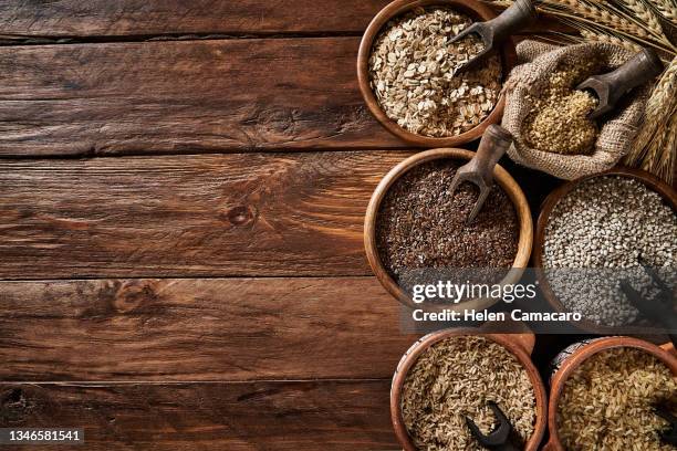 dietary fiber: variety of cereals on rustic wooden background with copy space. - rice cereal plant stock pictures, royalty-free photos & images