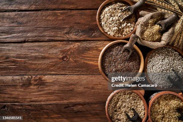 dietary fiber: variety of cereals on rustic wooden background with copy space. - trigo integral alimento básico - fotografias e filmes do acervo