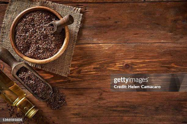 top view of flax seeds in a bowl and linseed oil on wooden backdrop. flaxseed dietary fiber - cereales stock pictures, royalty-free photos & images