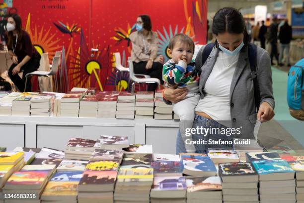 Woman with a child looks at books during the Turin International Book Fair on October 14, 2021 in Turin, Italy. The Turin International Book Fair...