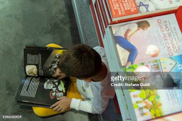 Child reads a book during the Turin International Book Fair on October 14, 2021 in Turin, Italy. The Turin International Book Fair returns to...