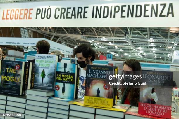 Sign saying "Reading can create independence" as people look at books during the Turin International Book Fair on October 14, 2021 in Turin, Italy....