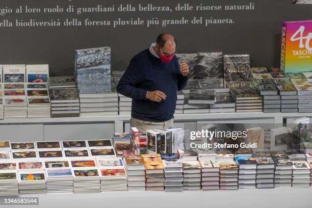 Man wearing a face mask looks at books on display during the Turin International Book Fair on October 14, 2021 in Turin, Italy. The Turin...