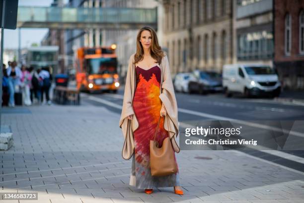 Alexandra Lapp is seen wearing The Row poncho, The Row brown bag, red dress Gabriela Hearst on October 08, 2021 in Dusseldorf, Germany.