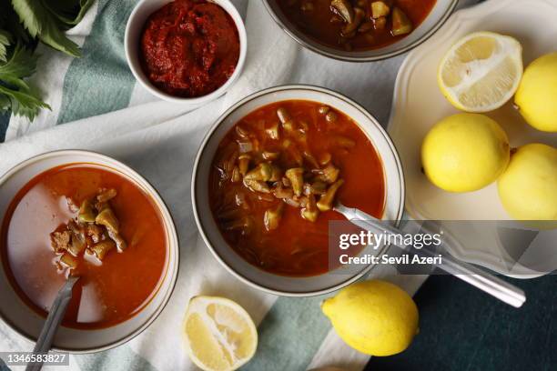 okra soup with tomato paste and meat with two bowls of lemon on a white napkin - okra stock pictures, royalty-free photos & images