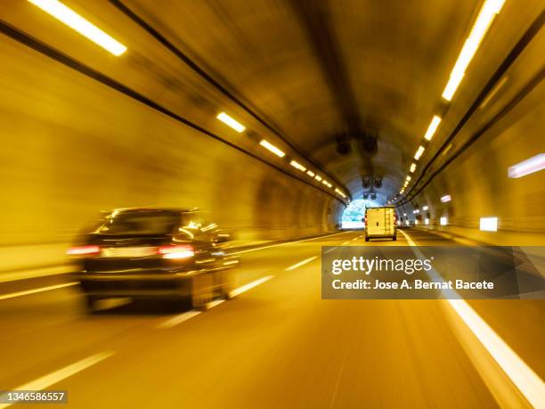 car point of view driving, cars moving through a lighted tunnel on a highway. - light at the end of the tunnel car stock pictures, royalty-free photos & images