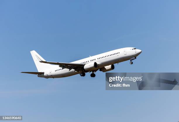 white passenger aircraft in the blue sky - air travel stock pictures, royalty-free photos & images