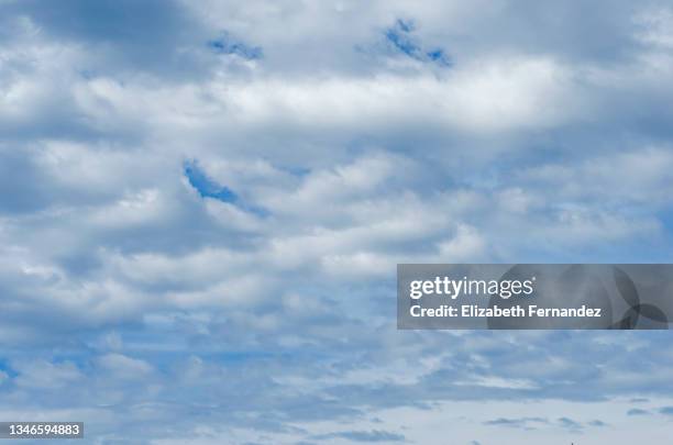 full frame of the low angle view of white color clouds with a blue sky. - grey clouds stock pictures, royalty-free photos & images