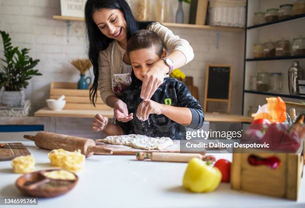 the family kneads the dough in the home kitchen - mother and daughter cooking photos et images de collection