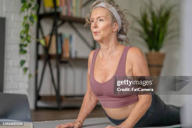 senior woman stretching at home - fat woman muscle pose stock pictures, royalty-free photos & images