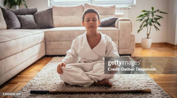 boy training martial arts moves at home. - child judo stock pictures, royalty-free photos & images