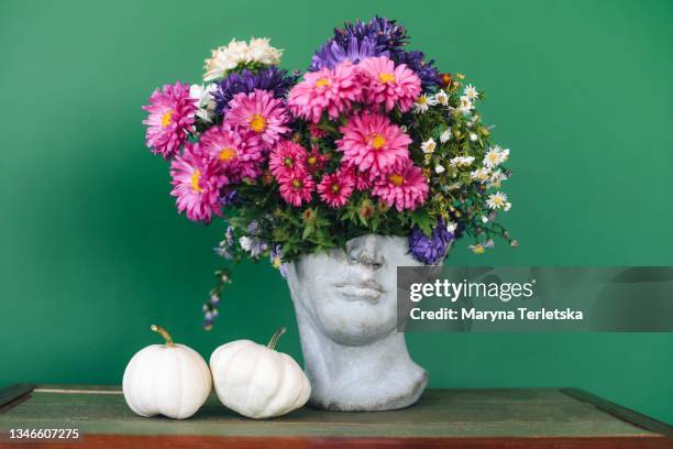 head-shaped vase with a bouquet of flowers. - vase photos et images de collection