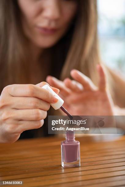 young woman applying nail polish at home - home manicure stock pictures, royalty-free photos & images