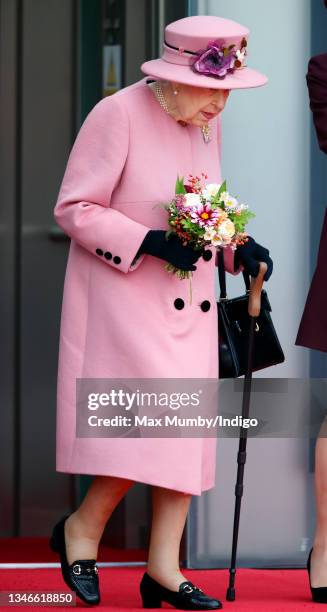 Queen Elizabeth II seen using a walking stick as she attends the opening ceremony of the sixth session of the Senedd at The Senedd on October 14,...