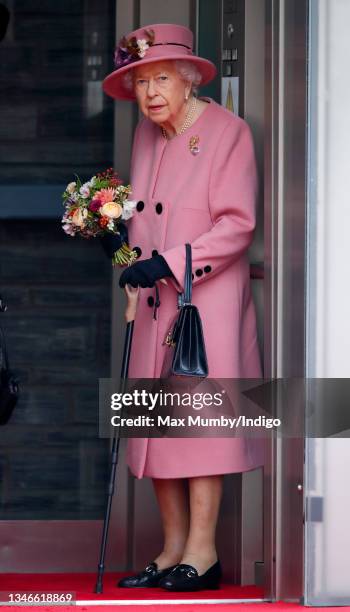 Queen Elizabeth II seen using a walking stick as she steps out of an elevator after attending the opening ceremony of the sixth session of the Senedd...