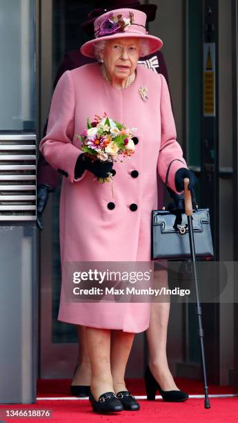 Queen Elizabeth II seen using a walking stick as she steps out of an elevator after attending the opening ceremony of the sixth session of the Senedd...