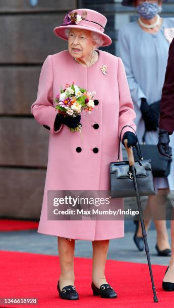 Queen Elizabeth II seen using a walking stick as she attends the opening ceremony of the sixth session of the Senedd at The Senedd on October 14,...