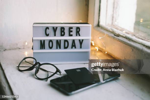 cyber monday symbol. lightbox with text cyber monday, eyeglasses, payment cards and telehone. - cyber monday stock-fotos und bilder