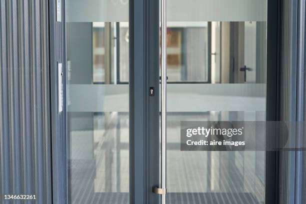 front view of glass and aluminum entrance door to the exterior of the corridors of a building - apartment front door foto e immagini stock