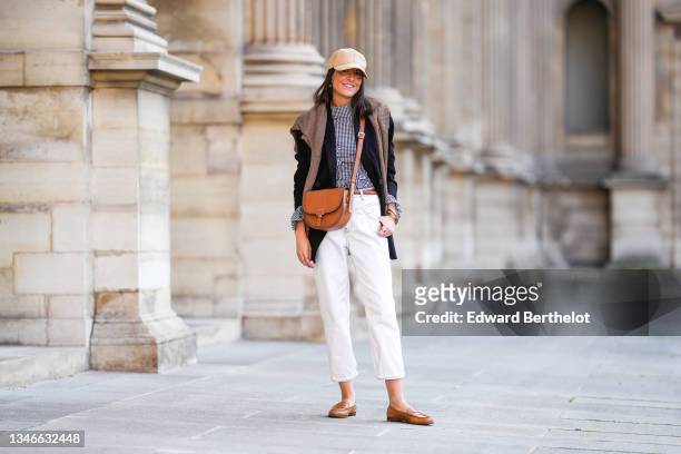 Alba Garavito Torre wears a wicker cap, a gingham black and white shirt with Long Sleeve Ruffles from Serendipia, Mom jeans in white by Maison 123...