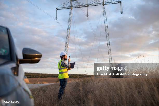 engineer working on power line in field. - telecommunications stock pictures, royalty-free photos & images