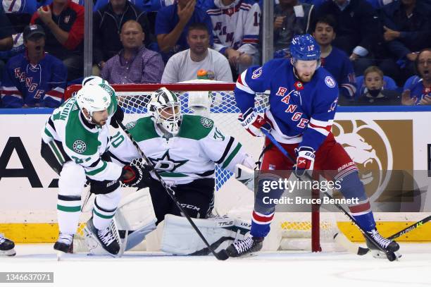 Alexis Lafreniere of the New York Rangers attempts to control the puck in front of Braden Holtby of the Dallas Stars during the first period at...