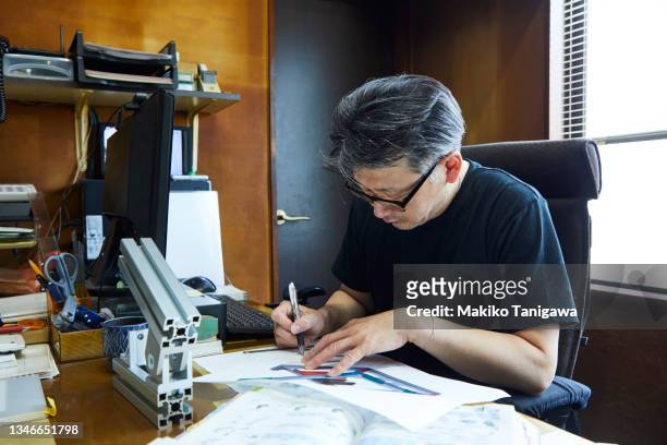 mature man working on a design in his workshop. - pen mockup stock-fotos und bilder