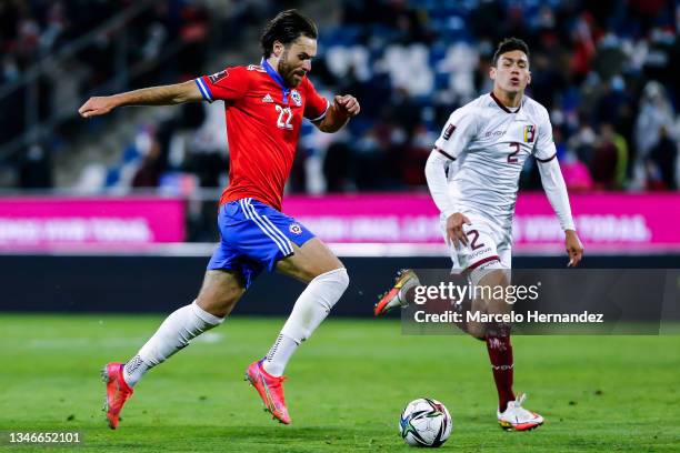 Ben Brereton of Chile drives the ball while followed by Nahuel Ferraresi of Venezuela during a match between Chile and Venezuela as part of South...