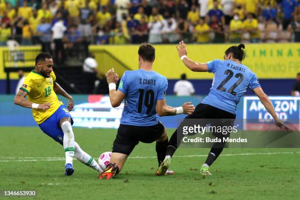 Neymar Jr. Of Brazil fights for the ball with Sebastian Coates and Joaquin Piquerez Moreira of Uruguay during a match between Brazil and Uruguay as...