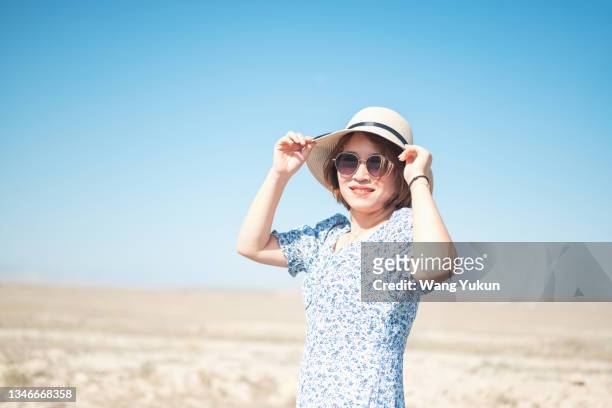 a frontal half-length photo of an asian woman wearing a sun visor looking into the camera - portrait frontal stock pictures, royalty-free photos & images