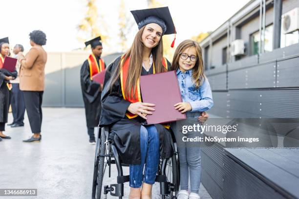 joven estudiante en silla de ruedas después de la ceremonia de graduación con su hija - disabilitycollection fotografías e imágenes de stock