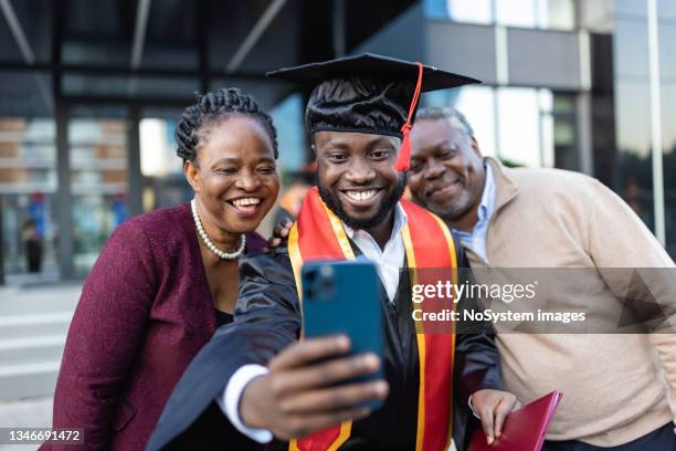 excited african american college graduate  with his family after the graduation ceremony - life event stock pictures, royalty-free photos & images