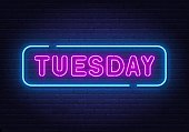 Tuesday neon sign on brick wall background.
