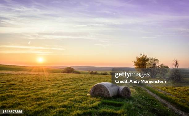 sunset with hay bales in a field - landscape in the bohemian ore mountains - high dynamic range imaging stockfoto's en -beelden