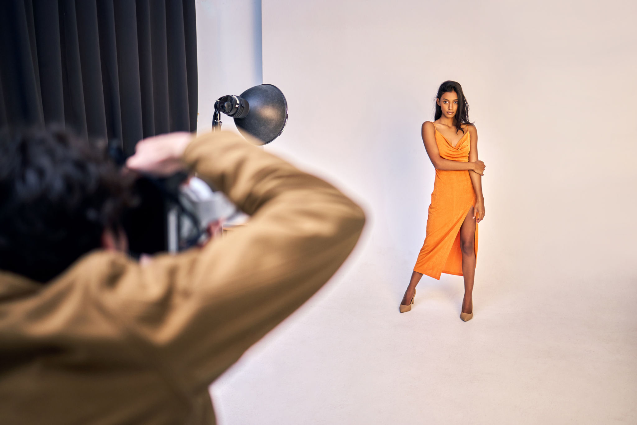 Shot of a photographer taking photos of a model in a studio Shot of a photographer taking photos of a model in a studio