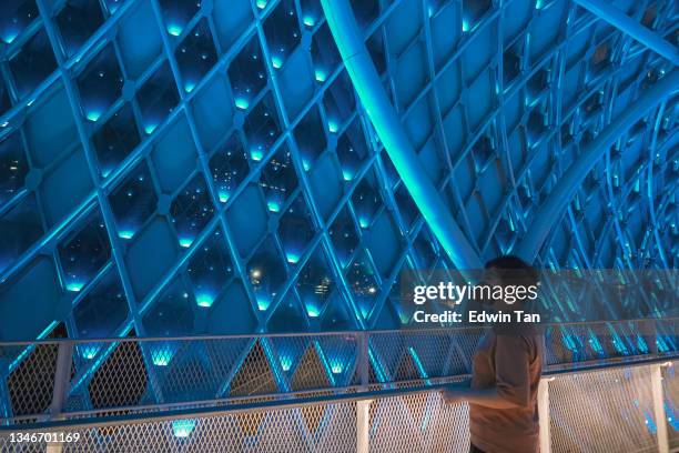 asian chinese mid adult woman tourist visit  kuala lumpur saloma bridge at night admiring photographing the colourful bridge illuminated with led light - neon catwalk stock pictures, royalty-free photos & images