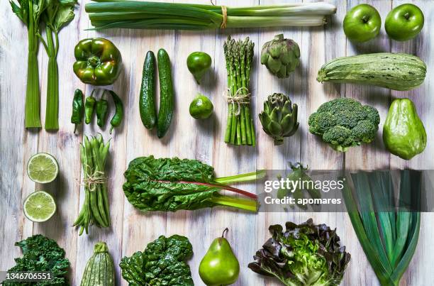 table top view background of a variation green vegetables for detox and alkaline diet. set on a white rustic table. food knolling. - alkaline stockfoto's en -beelden