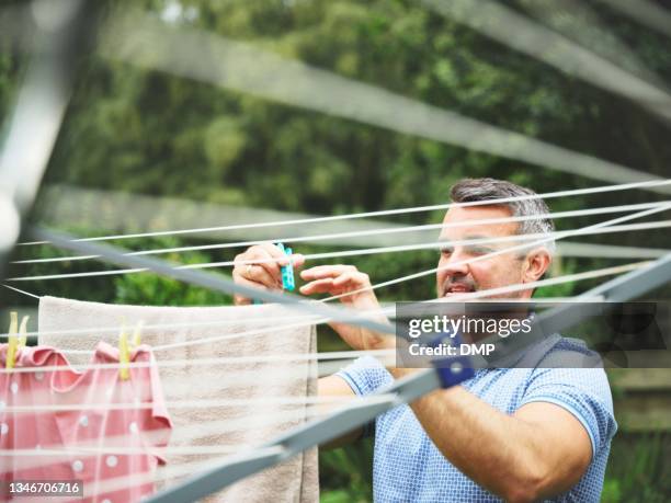 shot of a mature man hanging his laundry outside - draped stock pictures, royalty-free photos & images