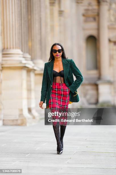 Emilie Joseph @in_fashionwetrust wears a vintage velvet fitted blazer in emerald green, a mid length pencil checked / tartan / gingham red slit...