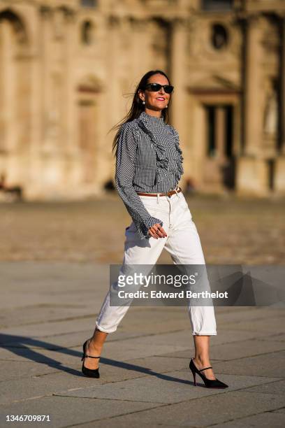 Alba Garavito Torre wears a gingham checkered black and white shirt with Long Sleeve Ruffles from Serendipia, Mom jeans in white from Maison 123...