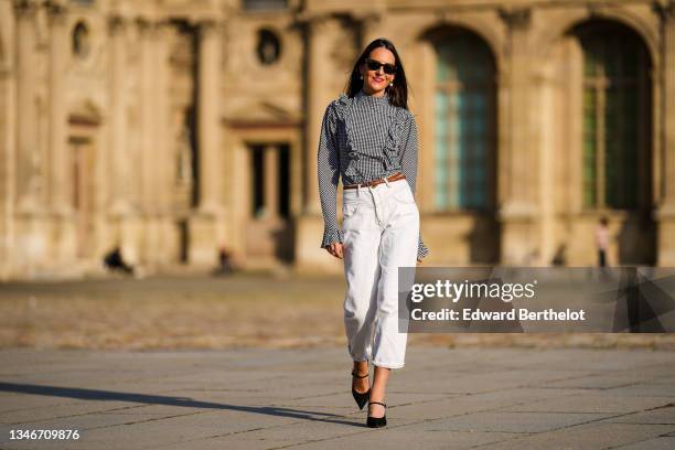 Alba Garavito Torre wears a gingham checkered black and white shirt with Long Sleeve Ruffles from Serendipia, Mom jeans in white from Maison 123...