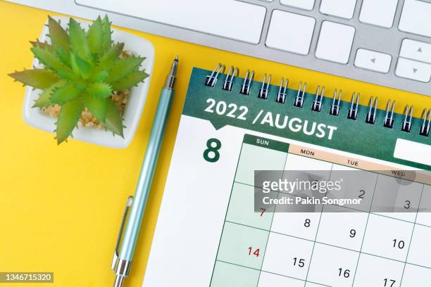 top view of calendar desk 2022 august month for organizer to planning and reminder on yellow background. business planning appointment meeting concept - august stock-fotos und bilder