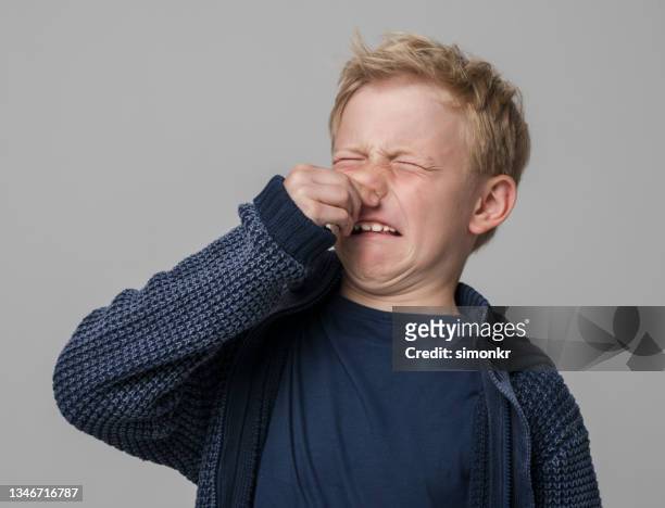 close-up of boy holding nose - ugly kids 個照片及圖片檔