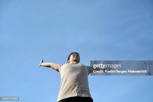 low angle view of teenage boy against sky. - kid looking up to the sky imagens e fotografias de stock