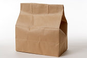 Isolated shot of closed brown paper bag on white background