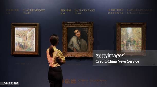 Visitor stands in front of Claude Monet's L'Escalier, Paul Cezanne's Portrait and Camille Pissarro's Le Lavoir de Bazincourt at Guardian Art Center...