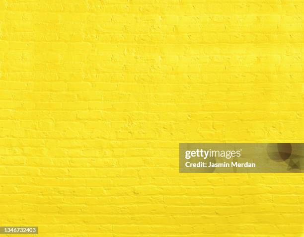 yellow brick wall, brickwall - tiled wall stock-fotos und bilder