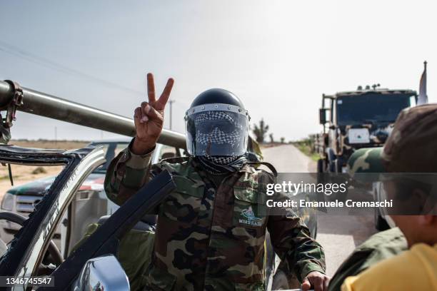 Militiaman of the Al Borkan brigade flashes the Victory sign as he celebrates the fall of Libya's ex-strongman Muammar Gaddafi while returning from...